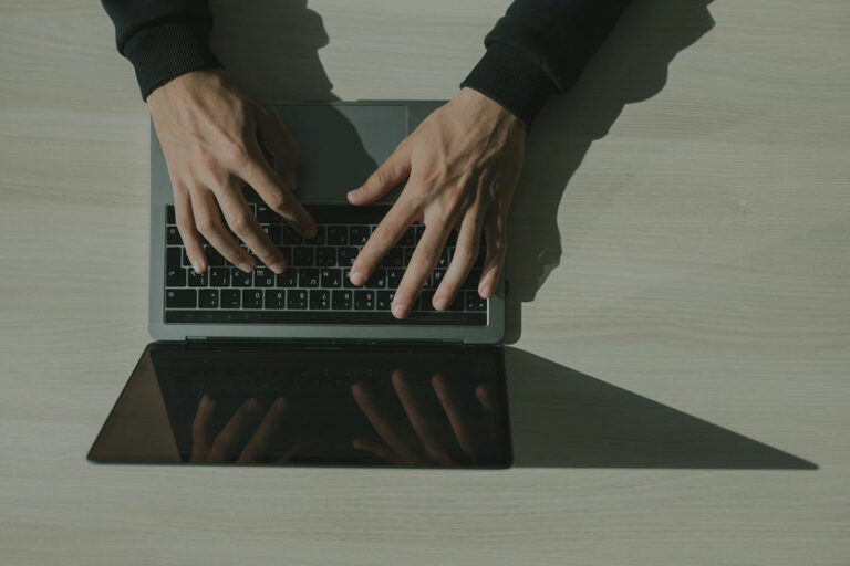 Overhead shot of someone typing on a laptop.
