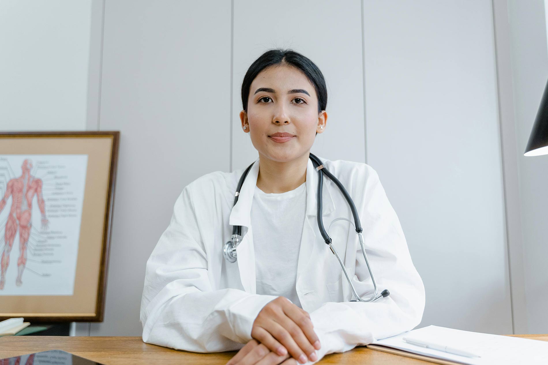 Doctor with stethoscope sitting at a desk